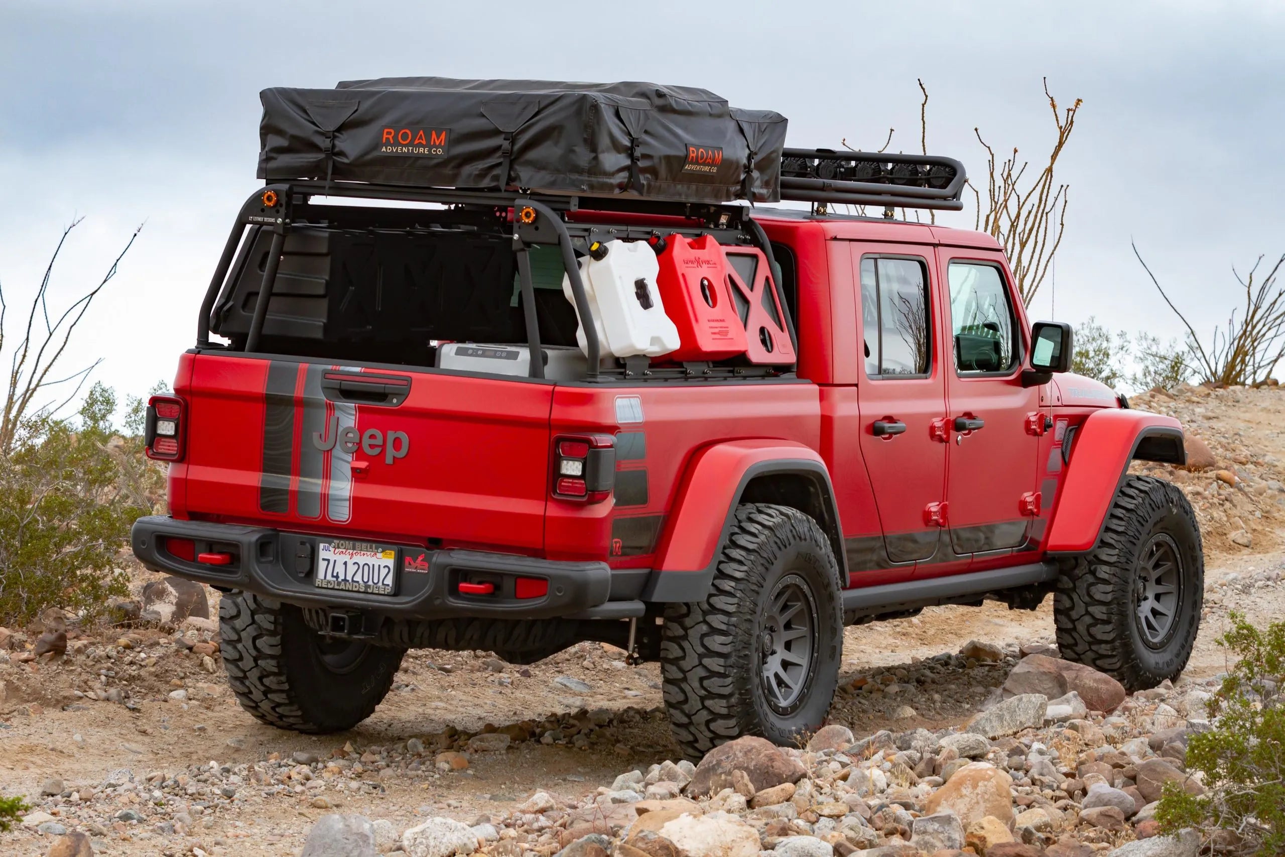 TrailRecon Jeep Gladiator JT exploring backcountry trail with rooftop tent and recovery accessories