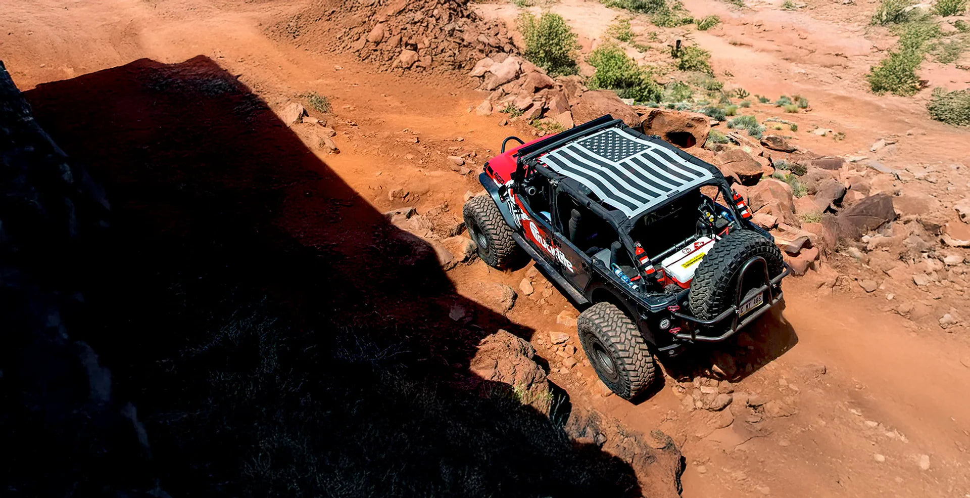Jeep Wrangler JK 4‑Door fitted with premium mesh shade top installed over open‑air roll‑cage on sunny off‑road trail