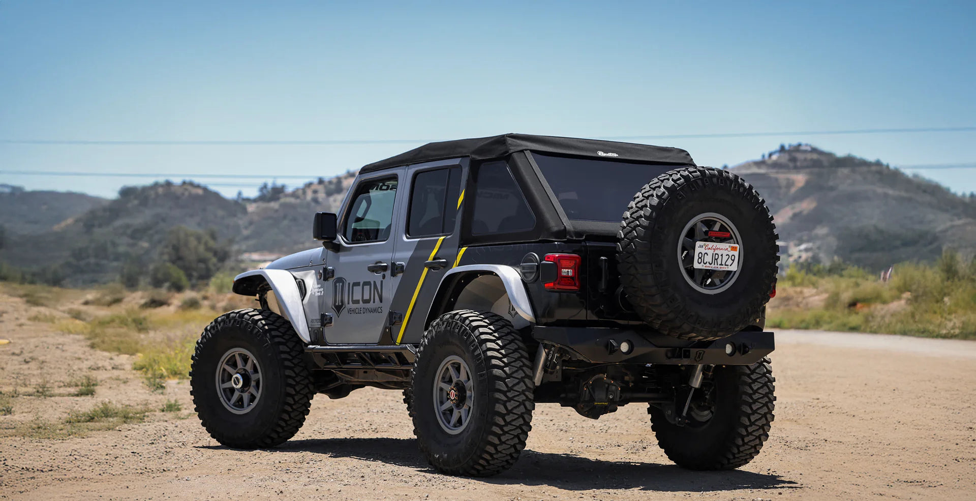 Jeep Wrangler JL 4-Door fitted with premium soft top accessory on off-road trail